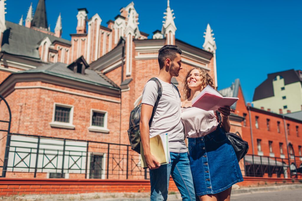 mixed race couple college students walking by university with copybooks young arab man white woman studying outdoors 1